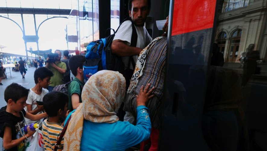 Une famille de migrants monte à bord d'un train en direction de l'Autriche et de l'Allemagne, dans la gare de Budapest-Keleti, le 31 août 2015