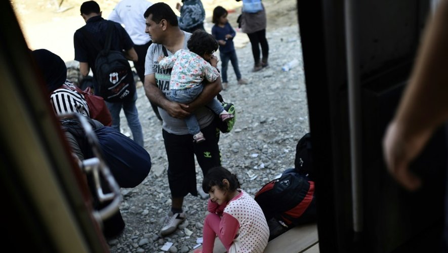 Des migrants attendent pour monter dans un train entre Guevgueliya, en Macédoine, et la Serbie, le 30 août 2015
