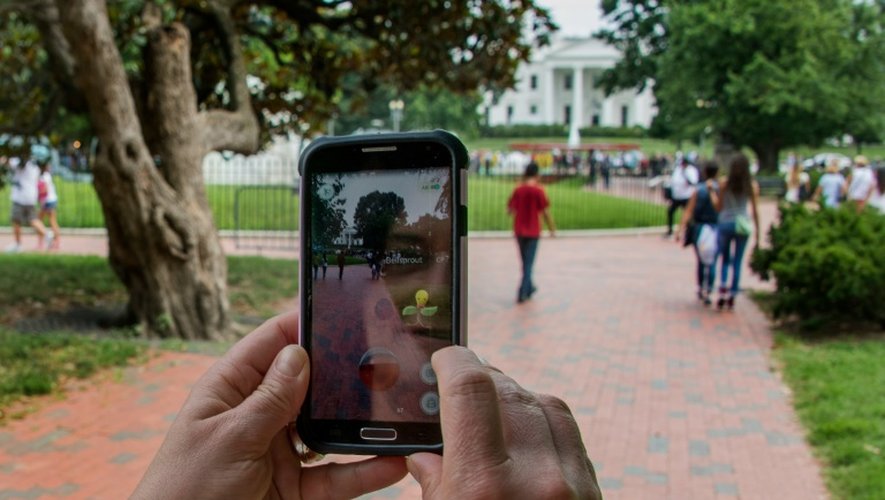 Une femme se promène dans la rue en jouant au Pokemon Go sur son téléphone, le 21 juillet 2016 à Washington