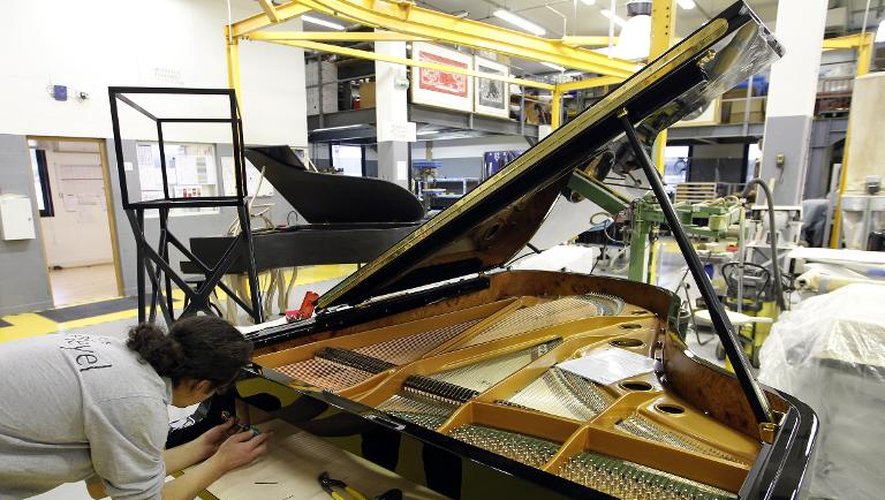 Une employée travaille à l'assemblage d'un piano Pleyel, le 3 décembre 2010, dans les ateliers de Saint-Denis, près de Paris