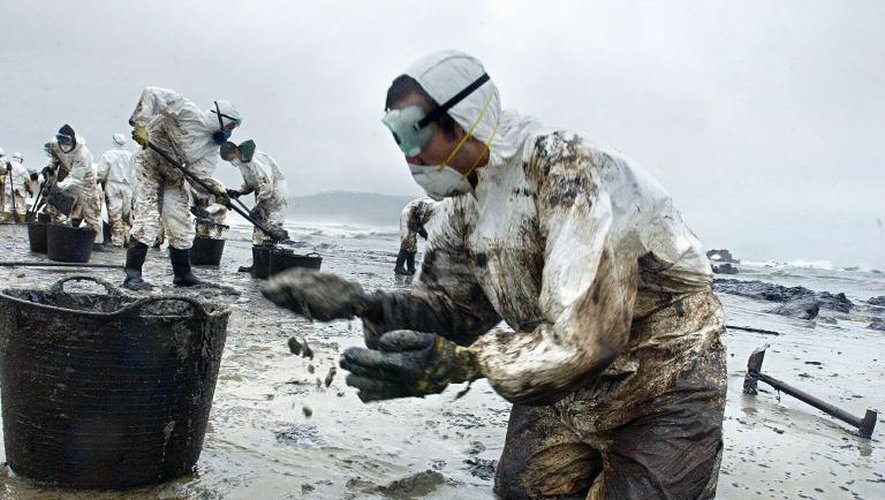 Des volontaires nettoient une plage de la pollution provoquée par le naufrage du pétrolier Le Prestigue, le 1er décembre 2002, à Nemina, en Espagne