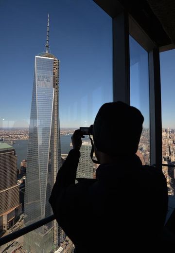 Un visiteur photographie la tour en construction One World Trade Center, depuis le 68e étage de la 4 World Trade Center, inaugurée le 13 novembre 2013 à New York