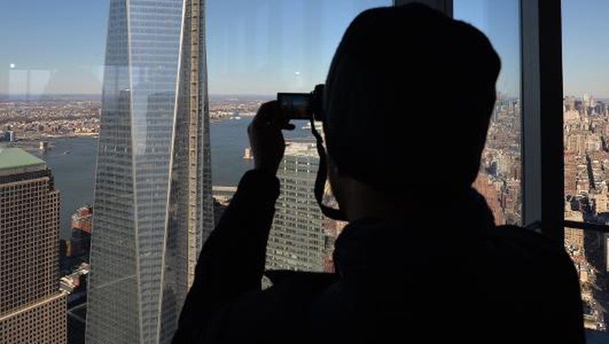 Un visiteur photographie la tour en construction One World Trade Center, depuis le 68e étage de la 4 World Trade Center, inaugurée le 13 novembre 2013 à New York