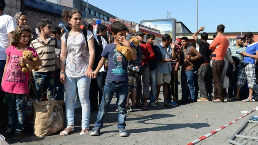 Des migrants attendent le bus après leur arrivée à la gare de Munich, le 1er septembre 2015