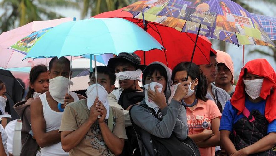 Des survivants se protègent de l'odeur des cadavres le 14 novembre 2013 à Taclogan