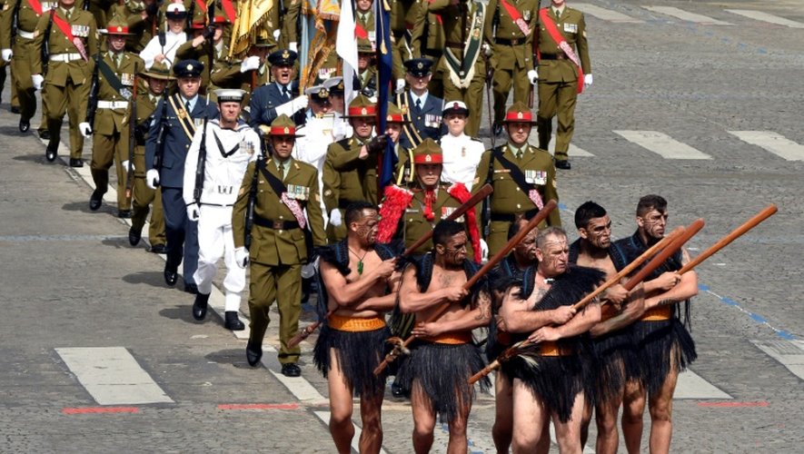 Six guerriers maoris de Nouvelle-Zélande défilent sur les Champs Elysée en tenue traditionnelle, torse et pieds nus, le 14 juillet 2016 à Paris