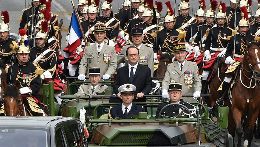 François Hollande entre le gouverneur militaire de Paris Bruno Le Ray et le général Pierre de Villiers à leur arrivée sur les Champs Elysées pour le traditionnel défilé le 14 juillet 2016 à Paris