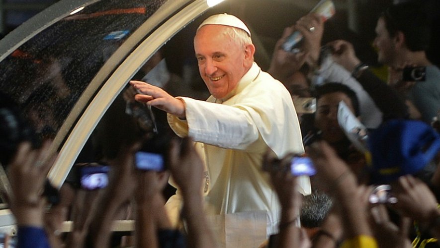 Le pape François salue les fidèles à Rio, depuis sa papamobile, après une messe, le 27 juillet 2013