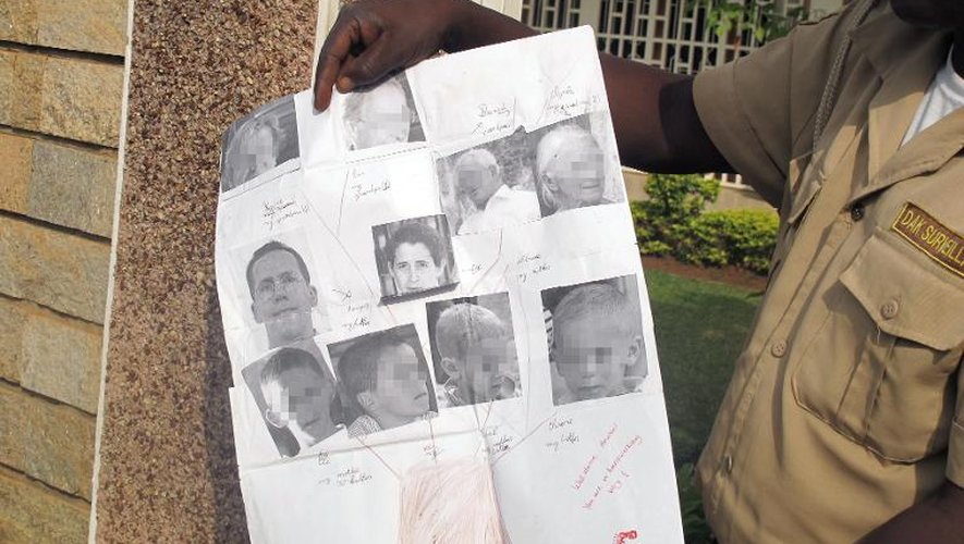 Un garde montre le 21 février 2013 les photos de la famille Moulin-Fournier enlevée le 19 février 2013 au Cameroun