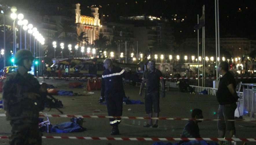 Policiers et pompiers autour des corps alignés sur le lieu de l'attentat le 15 juillet 2016 à Nice