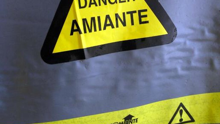 Une bâche portant un symbole de danger couvre, le 02 juillet 2002 à Paris, un endroit d'un bâtiment où de l'amiante a été utilisé pour l'isolation.