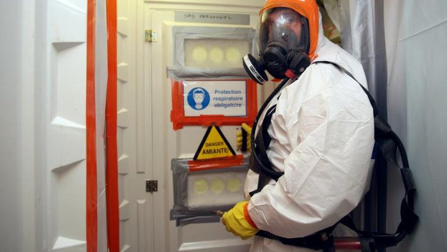 Un employé d'une entreprise de désamiantage, revêtu d'une combinaison spéciale, entre dans une zone contaminée par l'amiante du centre hospitalier universitaire (CHU) de Caen, le 23 avril 2010