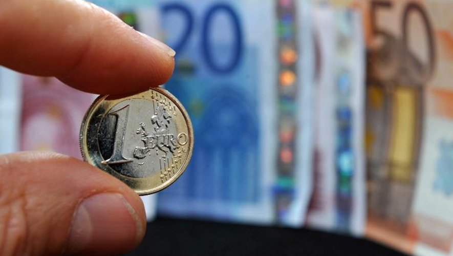 Une pièce de un euro et des billets en euros