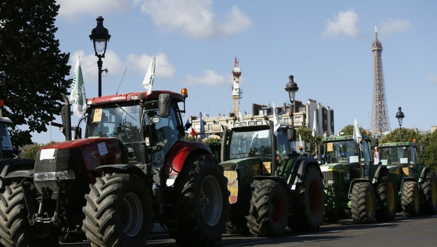 Un convoi de tracteurs dans les rues de Paris avec la tour Eiffel en arrière plan