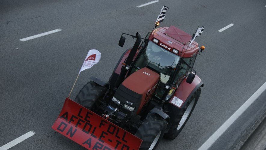 Un tracteur portant le slogan "Le Foll affole-toi, on arrive!" dans un convoi sur l'autoroute A13 près de Mantes-la-Jolie