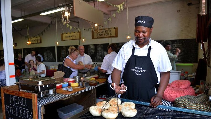 Un homme prépare des petits pains dans un café de Maboneng, quartier branché de Johannesburg, le 10 novembre 2013