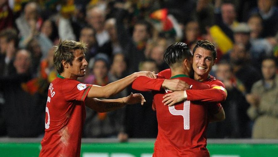 La joie de Cristiano Ronaldo, buteur pour le Portugal et félicité par ses coéquipiers Fabio Coentrao et Miguel Veloso, contre la Suède le 15 novembre 2013 à Lisbonne