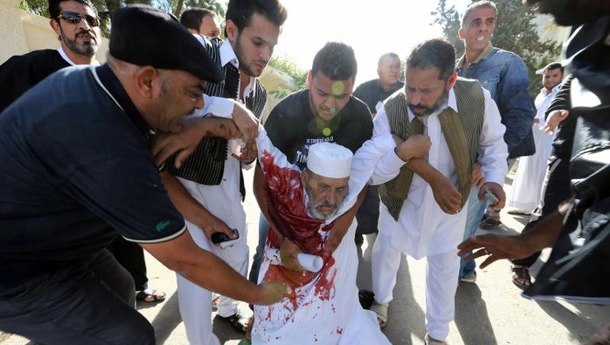 Un homme blessé lors d'une manifestation est secouru le 15 novembre 2013 à Tripoli