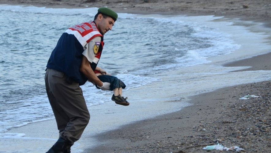 Un policier turc transporte le corps d'un enfant échoué sur une plage de Bodrum en Turquie, après le naufrage d'un bateau transportant des migrants, le 2 septembre 2015