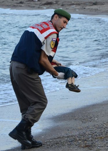 Un policier turc porte le corps d'un enfant migrant mort noyé, sur une plage de Bodrum, en Turquie, après le naufrage d'un bateau transportant des réfugiés, le 2 septembre 2015