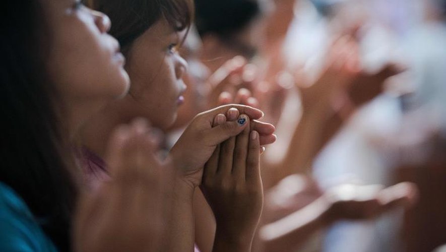 Des fidèles prient le 17 novembre 2013 pendant la messe à l'église de Santo Nino à Tacloban