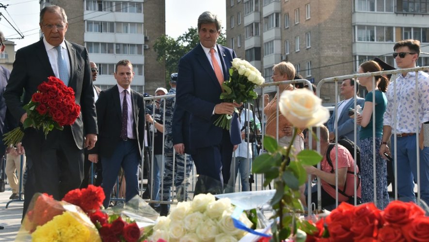Les chefs de la diplomatie russe et américaine, Sergueï Lavrov (G) et John Kerry, devant l'ambassade de France à Moscou pour y déposer des fleurs, le 15 juillet 2016