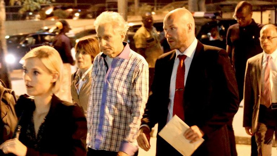 L'ex-otage français Francis Collomp (g) arrive à l'aéroport international d'Abuja, le 17 novembre 2013 au Nigeria