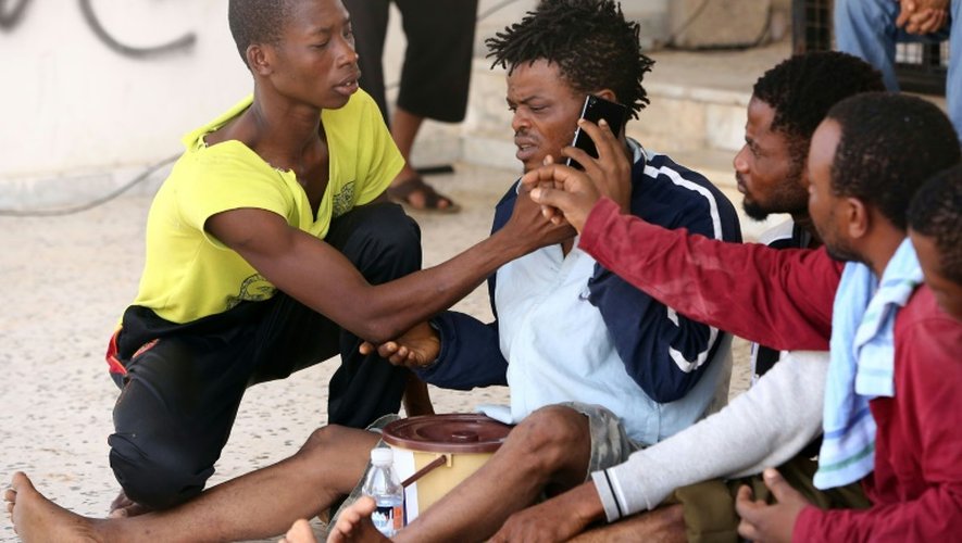 Des migrants rescapés d'un naufrage et secourus par des garde-côtes libyens téléphonent depuis un centre de sécurité situé entre les villes côtières de Subrata et de Zuwara, à l'ouest de Tripoli, le 28 août 2015