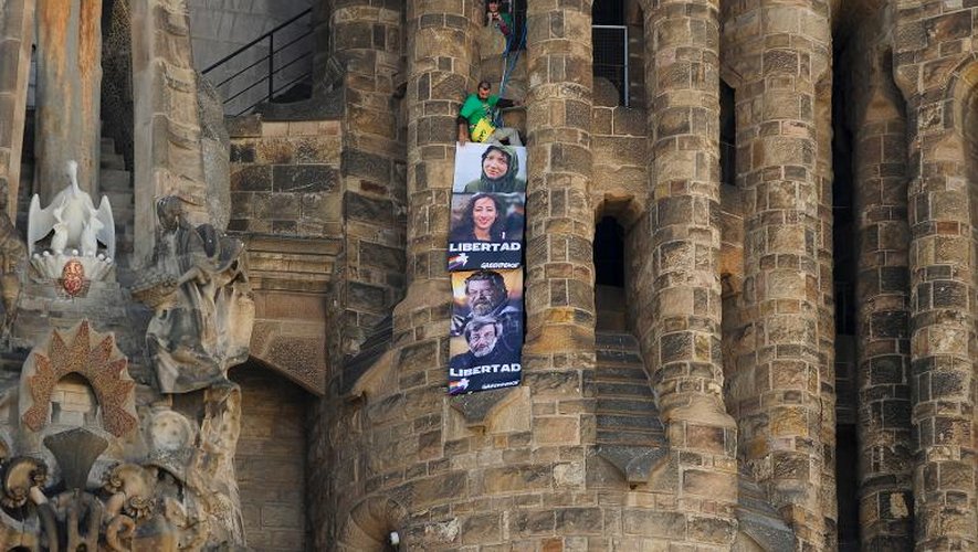 Des militants de Greenpeace accrochent des bannières, le 8 novembre 2013 sur la basilique de la Sagrada familia à Barcelone, en hommage aux membres du bateau de l'ONG arraisonné en septembre après une action dans l'Articque
