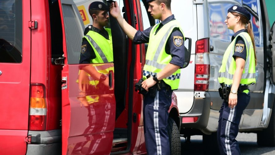 Des policiers autrichiens inspectent un véhicule à la frontière austro-hongroise à Nickeldsdorf, le 12 juillet 2016