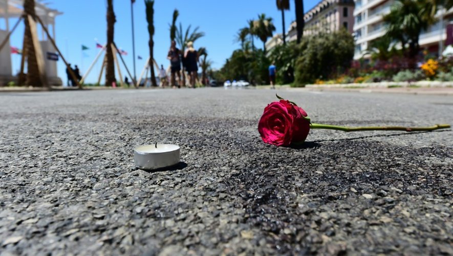 Une bougie et une fleur déposées sur une tâche de sang sur la Promenade des Anglais, le 16 juillet 2016 à Nice