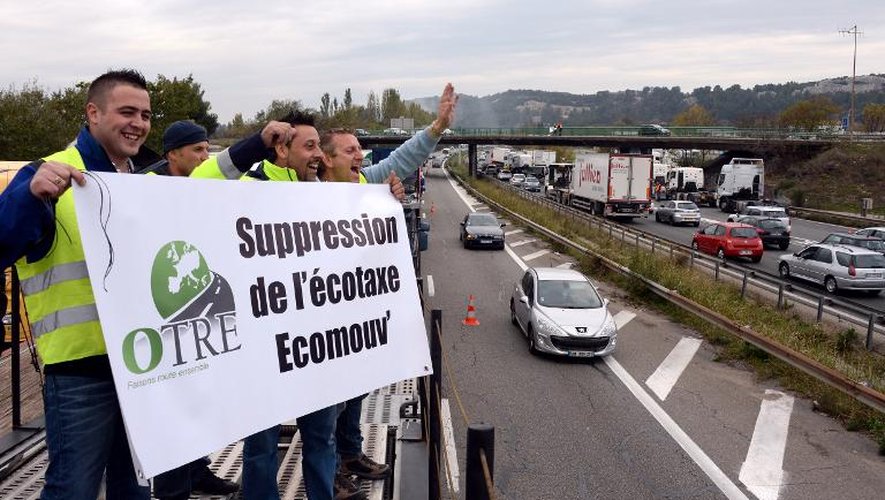 Des routiers brandissent une banderole pour la suppression de l'écotaxe en bloquant une partie de l'autoroute A7, à Pennes-Mirabeau, le 16 novembre 2013