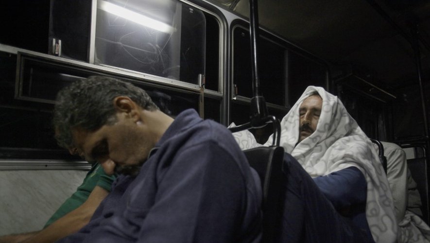 Des migrants dorment dans les bus qui les emmènent de Budapest vers la frontière austro-hongroise près du village de Hegyeshalom, le 5 septembre 2015