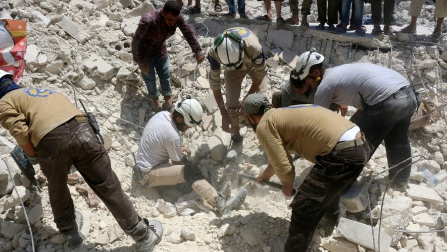 Des syriens recherchent des survivants après un bombardement dans le quartier de Karm Homad au nord d'Alep, le 17 juillet 2016