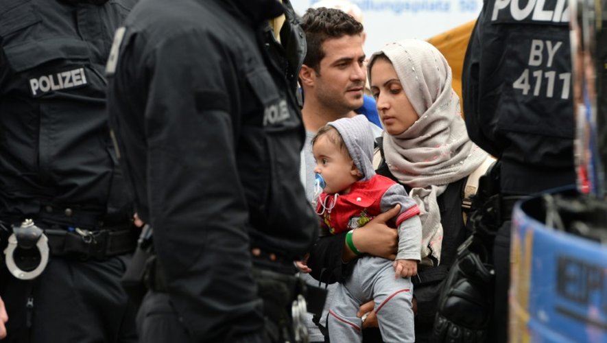 Une famille réfugiée attend un bus après son arrivée dans la gare centrale de Munich, dans le sud de l'Allemagne, le 5 septembre 2015