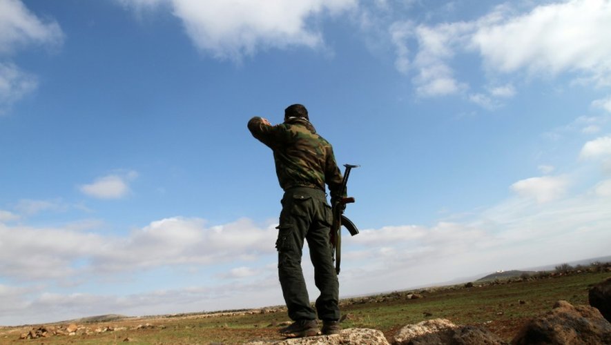 Un soldat syrien regarde en direction de la ville de Daraa depuis sa position à Soueida, dans le sud de la Syrie, le 23 janvier 2013