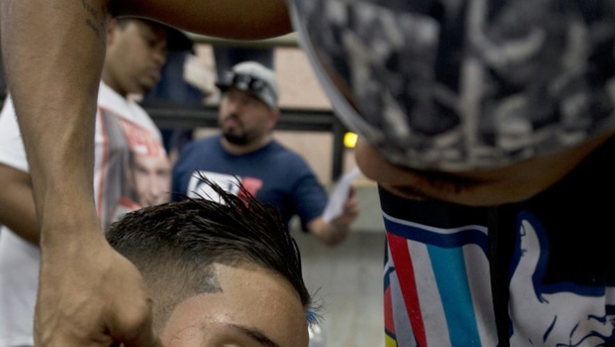 Un jeune homme se fait faire une coupe lors d'un concours de coiffure organisé dans une station de métro de Rio, le 2 septembre 2015