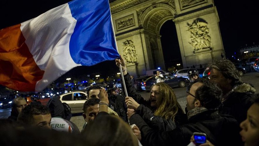 Des supporters fêtent la victoire des Bleus le 19 novembre 2013 sur les Champs Elysées à Paris