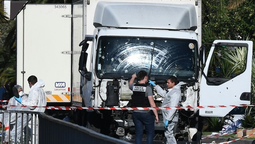 Des experts scientifiques de la police devant le camion criblé de balles de l'auteur de l'attentat sanglant de Nice, le 15 juillet 2016