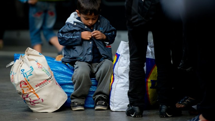Un garçonnet attend à la gare centrale de Munich avec des milliers d'autres migrants tout juste arrivés d'Autriche d'être dirigés vers des centres d'accueil, le 5 septembre 2015