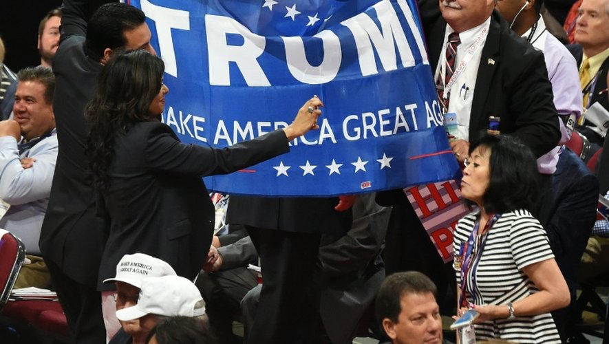 Une déléguée prend un selfie devant une banderole de soutien à Donald Trump à Cleveland le 18 juillet 2016