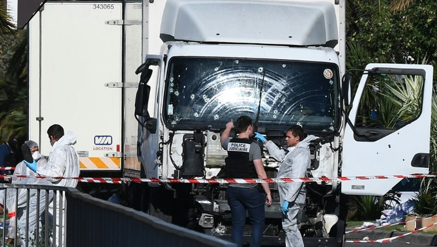 Des experts scientifiques de la police devant le camion criblé de balles de l'auteur de l'attentat sanglant de Nice, le 15 juillet 2016