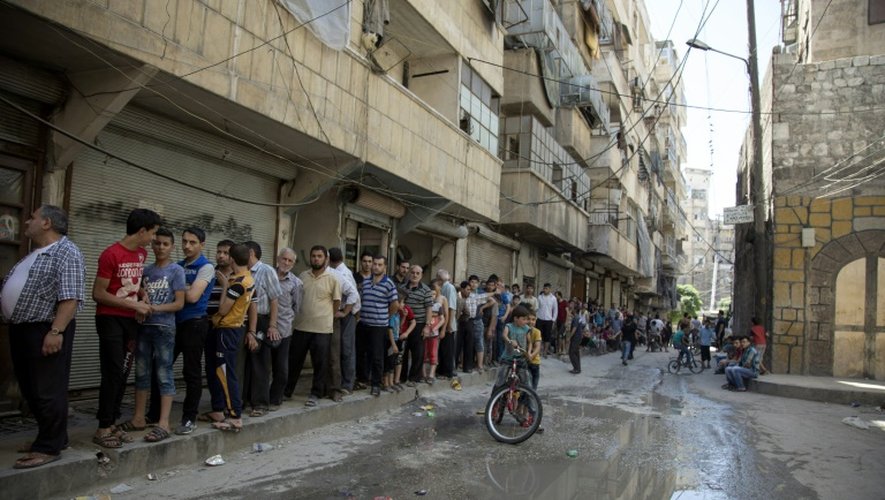 Des Syriens font la queue pour acheter du pain à Alep le 12 juillet 2016