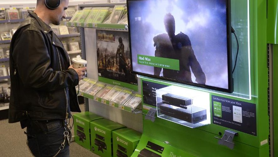 Un homme regarde un écran d'images de la Xbox One dans un magasin de New-York, le 19 novembre 2013