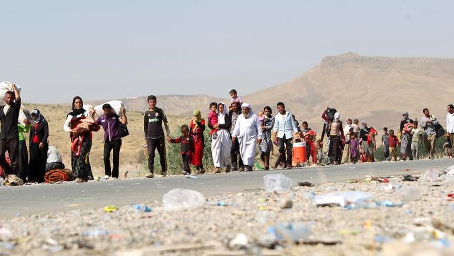 Sur les routes de l'exil, des familles irakiennes de la communauté yazidie déplacées par l'arrivée des jihadistes, ici sur la frontière irako-syrienne le 13 aout 2014 à Fishkhabur