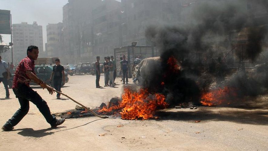 Des partisants du président déchu bloquent la route avec des pneus en feu dans les quartiers nord du Caire le 14 août 2014