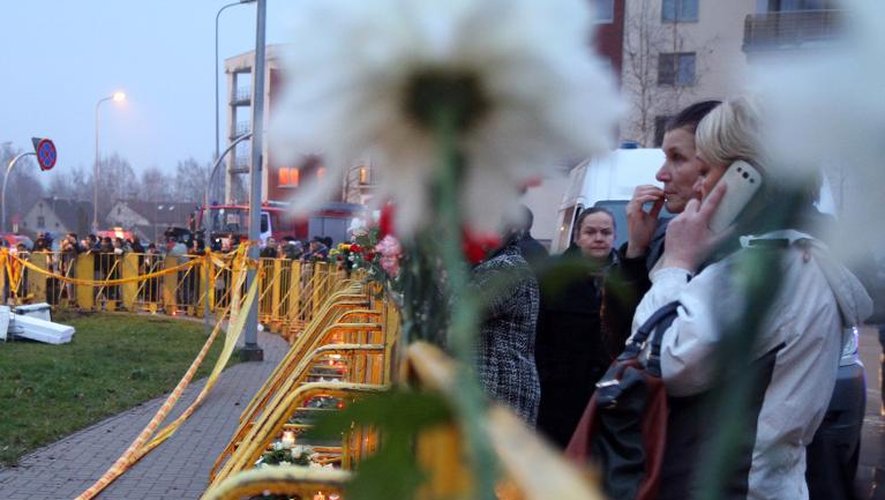 Des habitants de Riga déposent fleurs et bougies en hommage aux victimes tuées dans l'effondrement du toit d'un supermarché à Riga le 22 novembre 2013