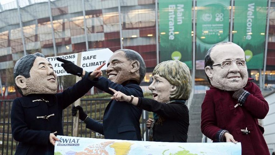 Des militants pro-climat portant des masques de Shinzo Abe, Barack Obama, Angela Merkel et François Hollande devant le stade national où se déroule la conférence sur le climat, le 22 novembre 2013 à Varsovie, en Pologne