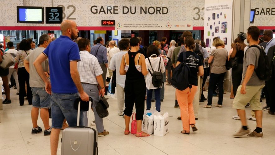 Des voyageurs devant un panneau d'information à la Gare du Nord à Paris, le 19 juillet 2016