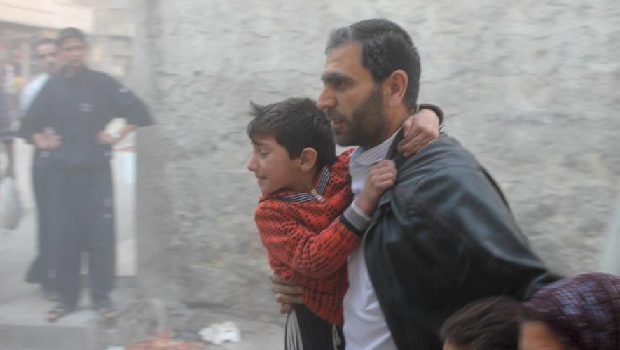 Un Syrien et ses enfants fuient le site d'un bombardement à Alep, le 16 novembre 2013